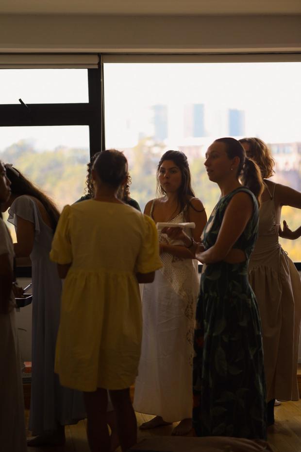 Guests talking at golden hour, Mexico City skyline through the window